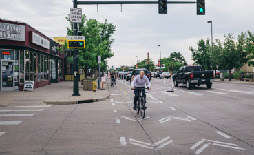 The two-way bike lane on Broadway is protected by parked cars, flex posts, and has bike signals and pavement markings at intersections for a safer ride. Photo: Robby Long