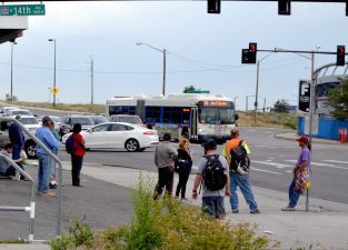 People wait at an RTD "bus stop" at the intersection of 14th Avenue, Federal Boulevard, and Howard Place. Photo: David Sachs