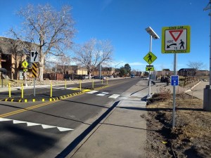 At a press event today, safer streets advocates highlighted a newly-installed protected pedestrian refuge island and pedestrian-activated flashing signal Albrook Drive in Montbello. Image: Denver Streets Partnership.