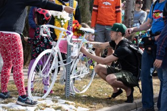 Daniel Clinton attaches a flower to the ghost bike.