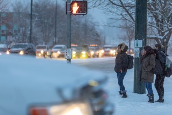 Young women wait to cross Colfax at Irving Street last week, not far from where a driver killed Raymond Hansford Jan. 3.
