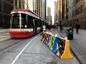 Using low-cost materials like this concrete divider, Toronto set up new streetcar stops on the far side of intersections on King Street, enabling safer boarding and cutting down on time stopped at red lights. Photo: Human Transit