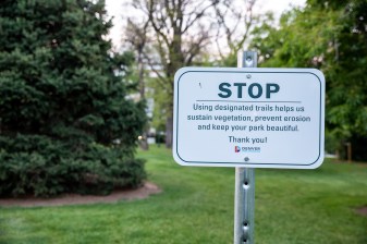 A sign directs people to stay on designated trails in Cheesman Park. Photo: Andy Bosselman