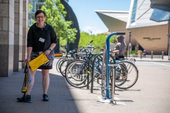 Amanda Armstrong, a business librarian, poses with a new bike kit next to a fixed repair station outside of the Central Library this afternoon. Photo: Andy Bosselman