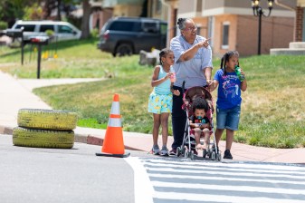 Lisa Ford walks her grandchildren, Cannon Castell; Jada Ford; and Chastity Castell, across a temporary crosswalk in Montbello June 15. Photo: Andy Bosselman