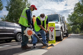 Department of Public Works employees install an in-street pedestrian sign on August 23. Under Proposition 2A, DPW would become the Department of Transportation and Infrastructure. Photo: Andy Bosselman