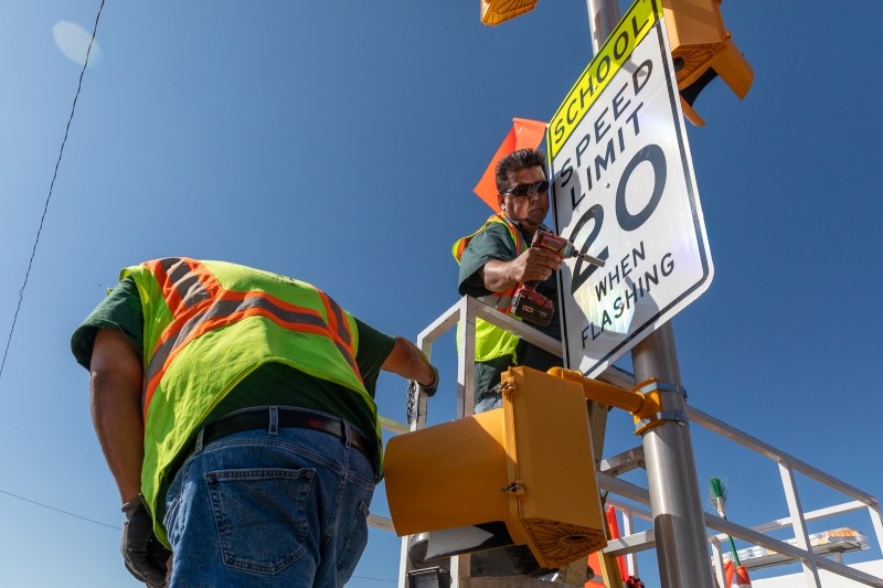 Danny Gonzales installs a 20 mph speed limit sign on Aug. 30, 2019. Photo: Andy Bosselman
