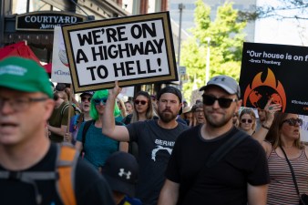 A man holds a sign reading "We're on a highway to hell!" while marching in the Global Climate Protest in downtown Denver on Sept. 20. Photo: Andy Bosselman, Streetsblog Denver