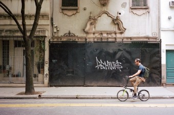 A man rides in a protected bike lane in Buenos Aries. Analog photo: Andy Bosselman