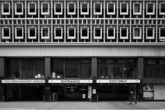 A woman with a cane walks in front of a mid-century modern building in Downtown Denver. Photo: Andy Bosselman