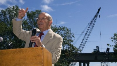 Photo Congressman Peter DeFazio (D-OR) speaks with a microphone at a lectern