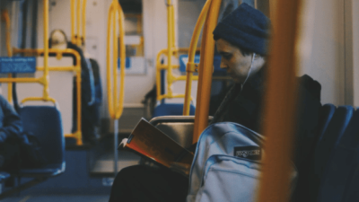 Photo a person reads while riding the bus