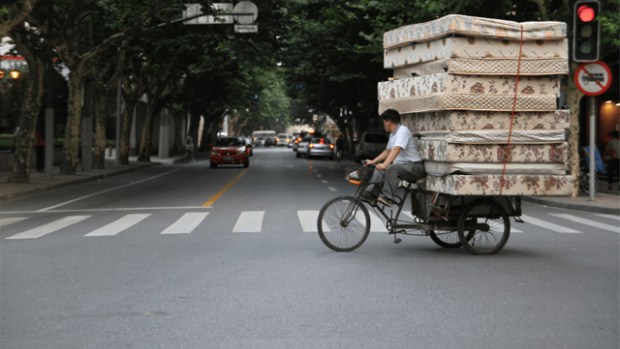 Bike rider on a cargo bike with ten mattresses