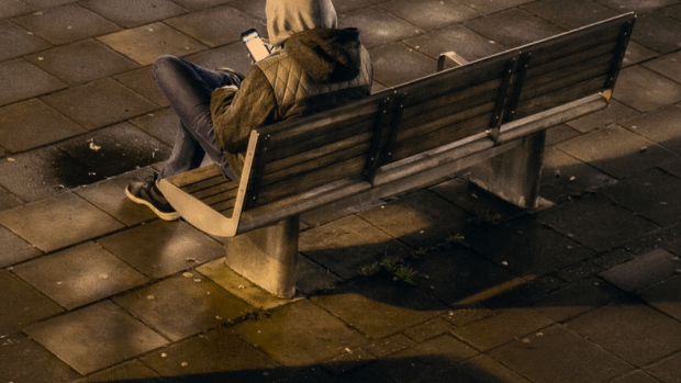 Photo person sitting on a bench outdoors