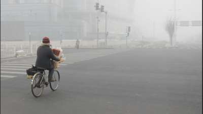 Photo person biking on a street in smog