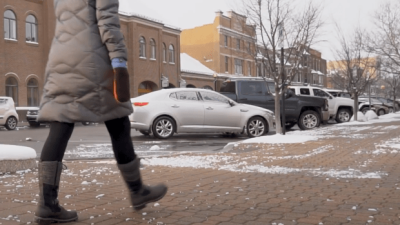 Person walking on snow-free sidewalk in Holland, Michigan