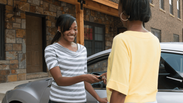 Adult handing car keys to a teen